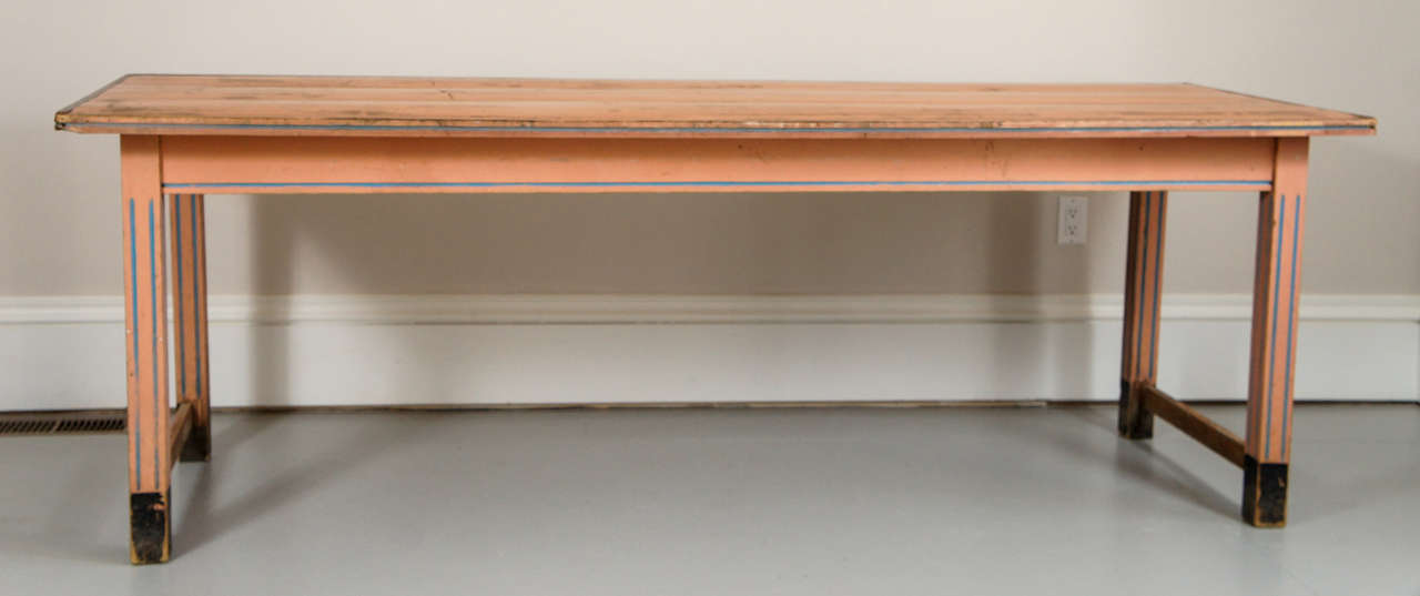  A large colorful country table in a salmon pink and blue stripe. The table has a nice patina and the top has a protective finish on it. The legs are fluted. A sturdy harvest table that comfortably seats 8 to 10.
