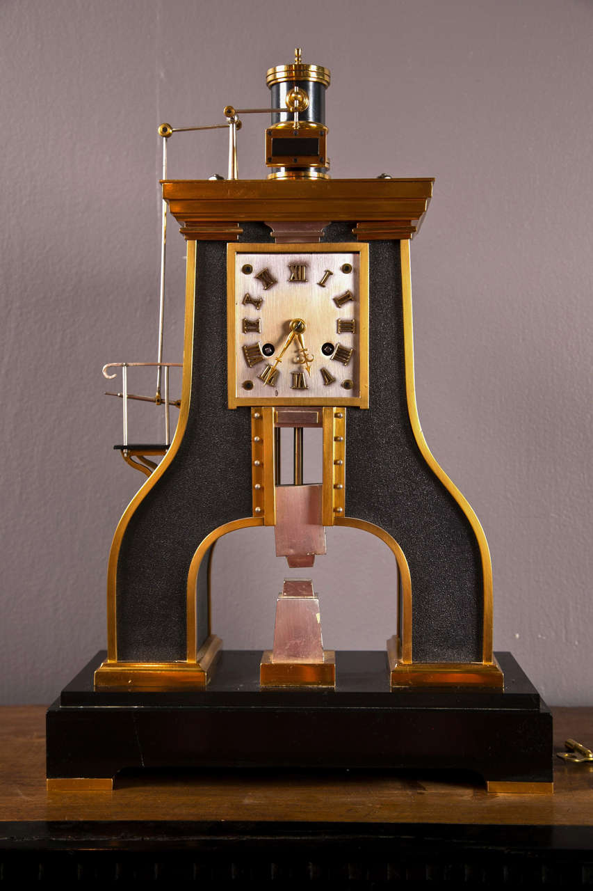 A French industrial steam hammer clock having piston cylinder on top.  Brass movement signed GLT Paris ( Guilemt ) and Japy Freres.
Clock is in fine working order.