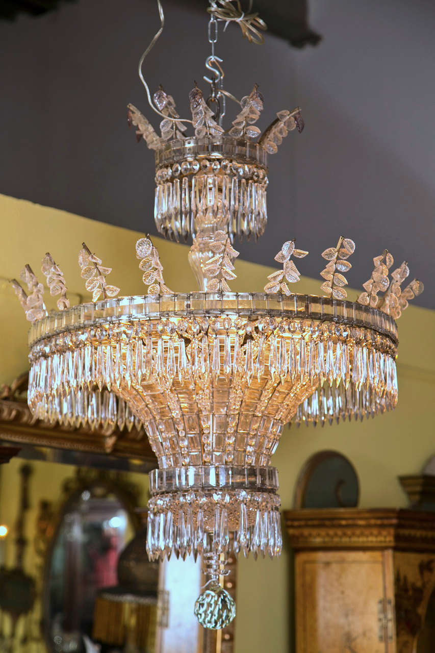 A very elegant crown and basket form three tier crystal and bronze chandelier.