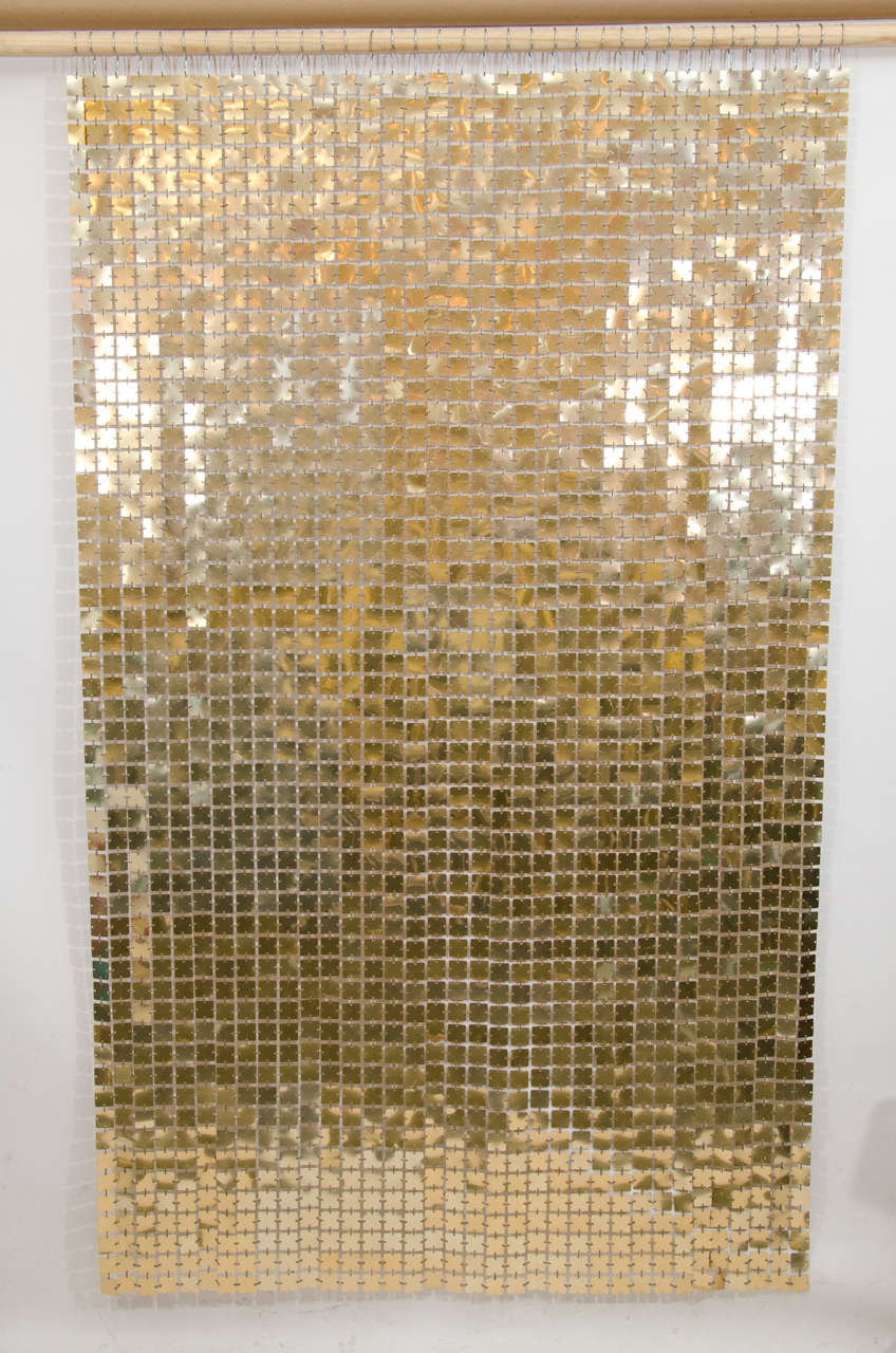 Gorgeous gold colored space curtain by Paco Rabanne. The curtain is comprised of the same links that he used on his iconic mini dresses: Plasticized metal squares joined by plastic gold colored clips. A versatile accent piece, it can be a wall