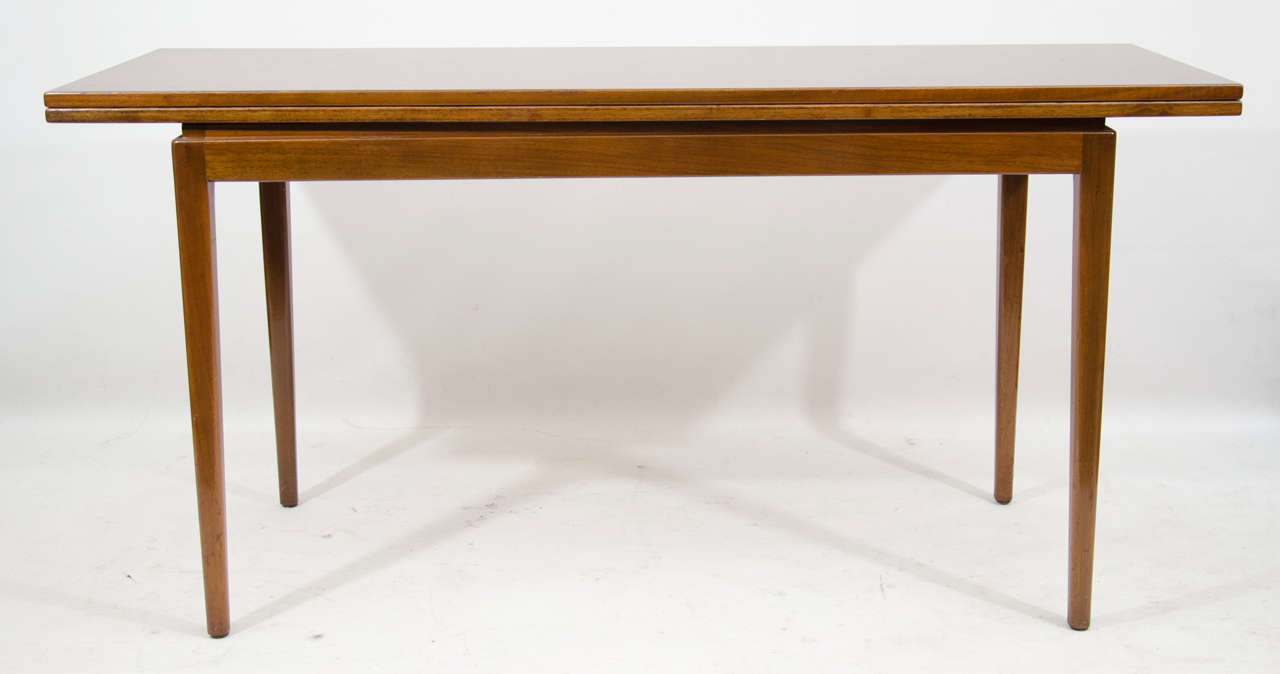 Handsomely designed and versatile mahogany console/dining table designed by Jens Risom. There is a felt lined compartment for flatware. Substantial and nicely detailed.. Opens to 42