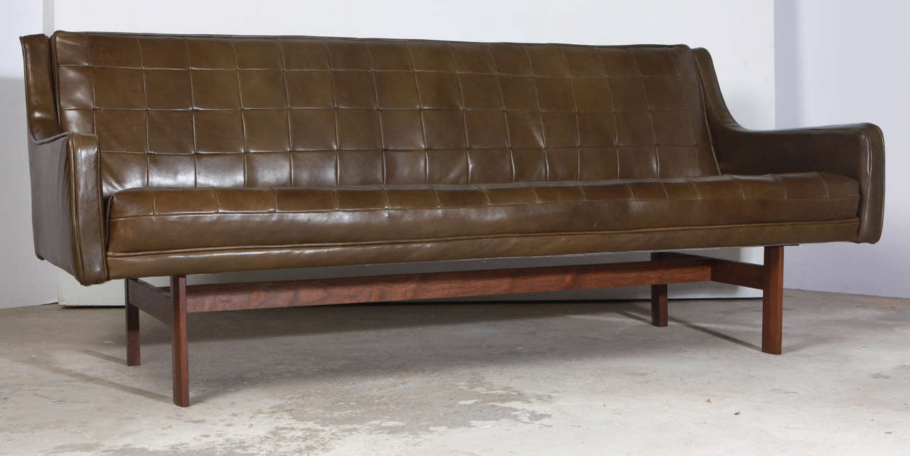 Sharp mid-century sofa in green leather on walnut base.