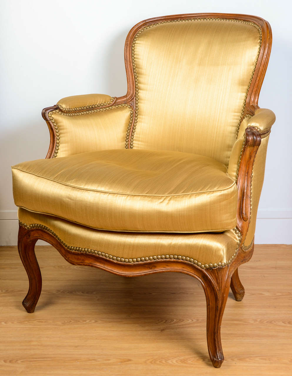 Bergere armchair with a natural wood carved cabriolet back. Curved armrests, belt and feet. Stamped 
