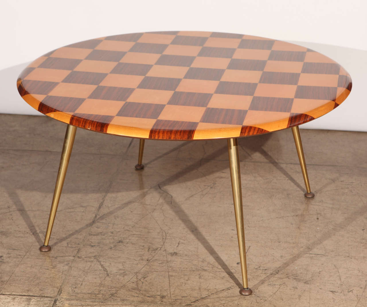 A mid century Italian checkered table. Made of sycamore and rosewood veneer on brass legs. Please note there is a slight veneer flaw on the edge of the table top.