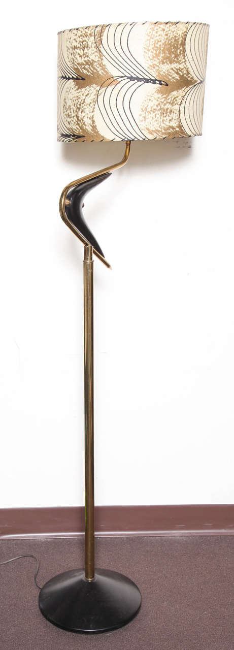1950's boomerang lamp. Beautiful sculptural design, polished brass. Enameled metal. Original fiberglass shade. Boomerang pivots for shade movement. 59 inches tall. Base 12 inches in diameter.Reduced from 1500.00 to 650.00