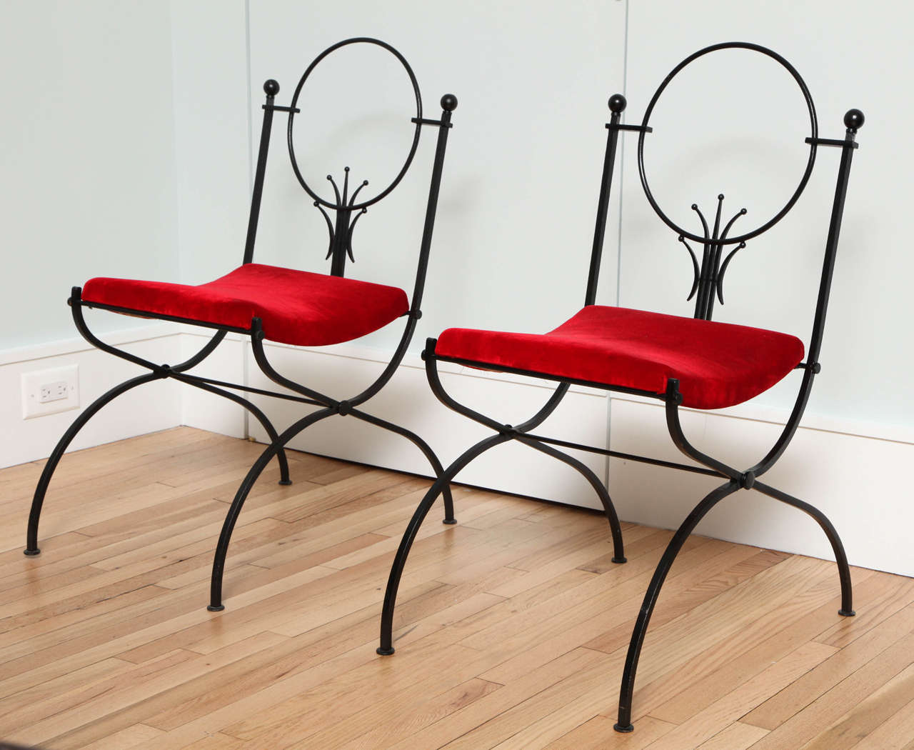 Pair of black-painted, wrought iron small chairs, attributed to Raymond Subes, circa 1950. Upholstered in red silk-velvet.