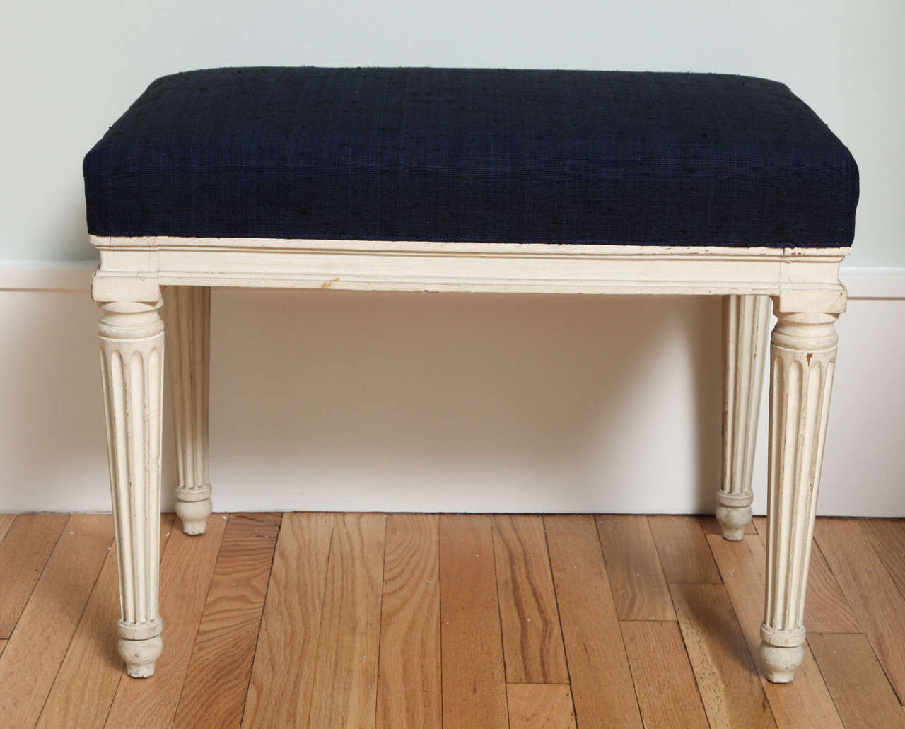 An 18th century French neoclassical stool from the collection of Mrs. Paul ("Bunny") Mellon, upholstered in the dark-blue, heavy cotton she selected for it.