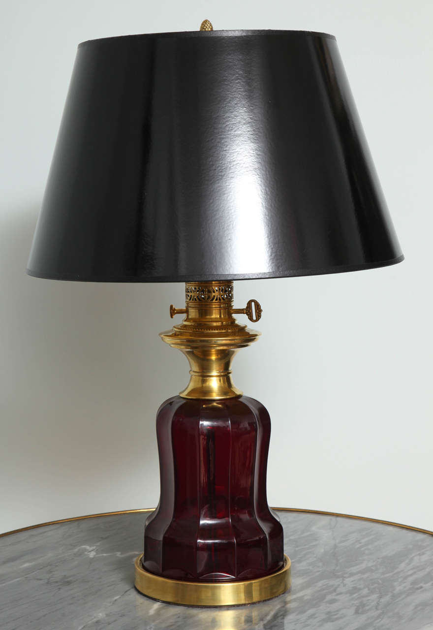 Diese stilvolle Mid-Century-Variante einer Öllampe aus dem späten 19. Jahrhundert wurde aus rubinrotem Glas und goldenem Messing gefertigt und ist jetzt mit einem maßgeschneiderten, hochglänzenden schwarzen Papierschirm ausgestattet.