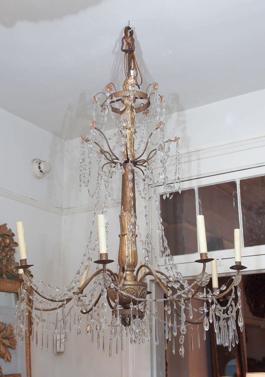 Pair of early 19th century two tiers Italian crystal chandeliers. Eight lights. US wired.
Carved giltwood body with iron arms. Top crown has orange crystals.