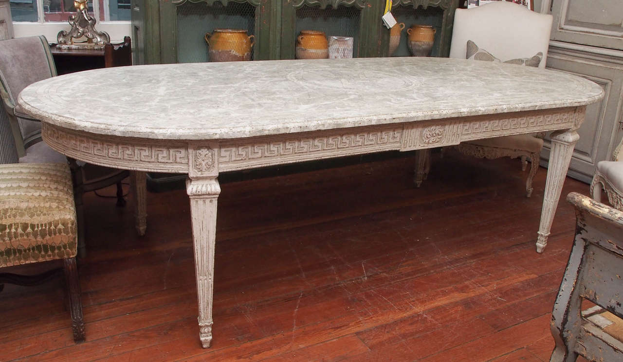 Late 19th century dining room table. Faux marble finish in gray and white with a center star design and a Greek motif on the apron. Square fluted carved legs.