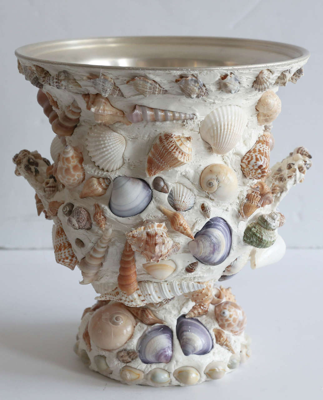 Vintage silver plate urn covered in shells.
