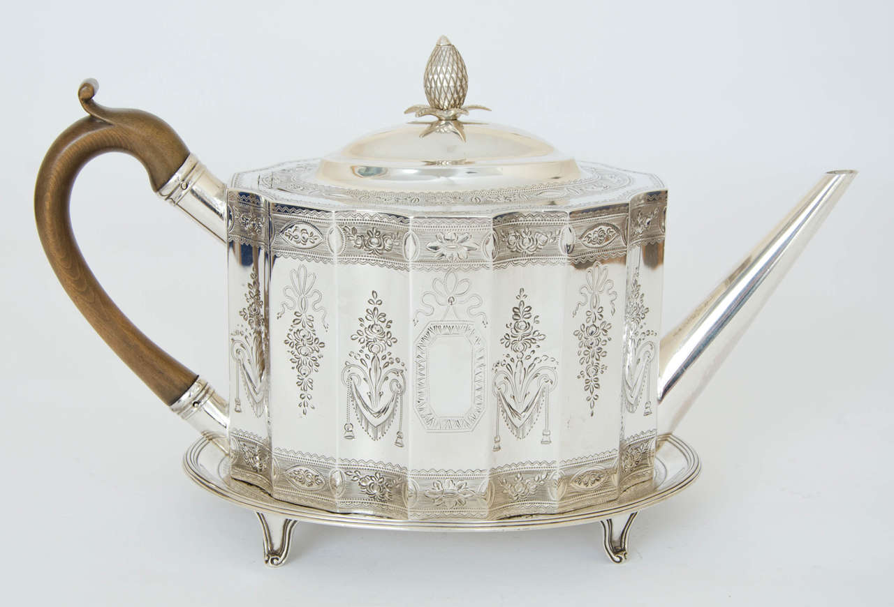 A superb George III antique silver tea pot and stand, the teapot is of serpentine shape with wonderful bright –cut engraving of flowers and foliage, with a vacant cartouche on either side. The bright –cut engraving is repeated on the teapot stand,