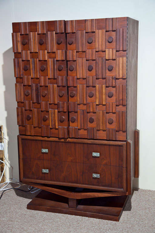 Tall chest done in maple with two internal shelves, four internal drawers and two outside drawers with bronze pulls. Sculptural front with round and rectangular applied detail. Base of this piece is an interesting Y-shape.  Large enough for plenty