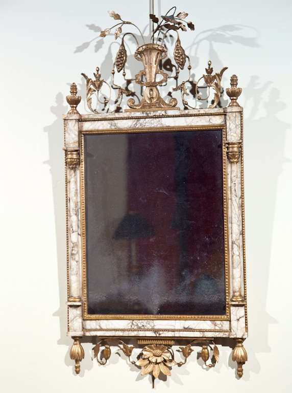 A Portuguese Bilbao marble framed mirror with a gilt wood urn, floral and pomegranate motif and engaged columns flanking the mirror plate.