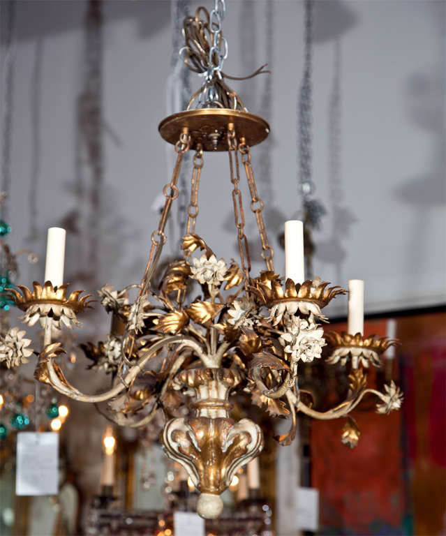 An Italian painted, carved and gilt, wood and tole four-light chandelier.