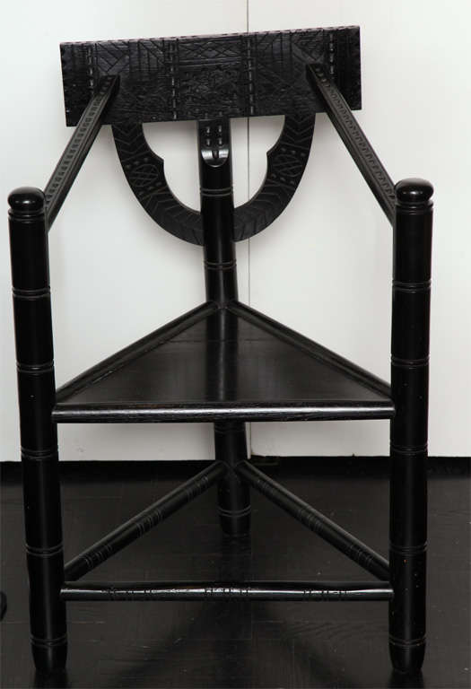 Early 20th Century ebonized oak carved Turner chair with triangular shaped seat, turned spindle back, arms and apron