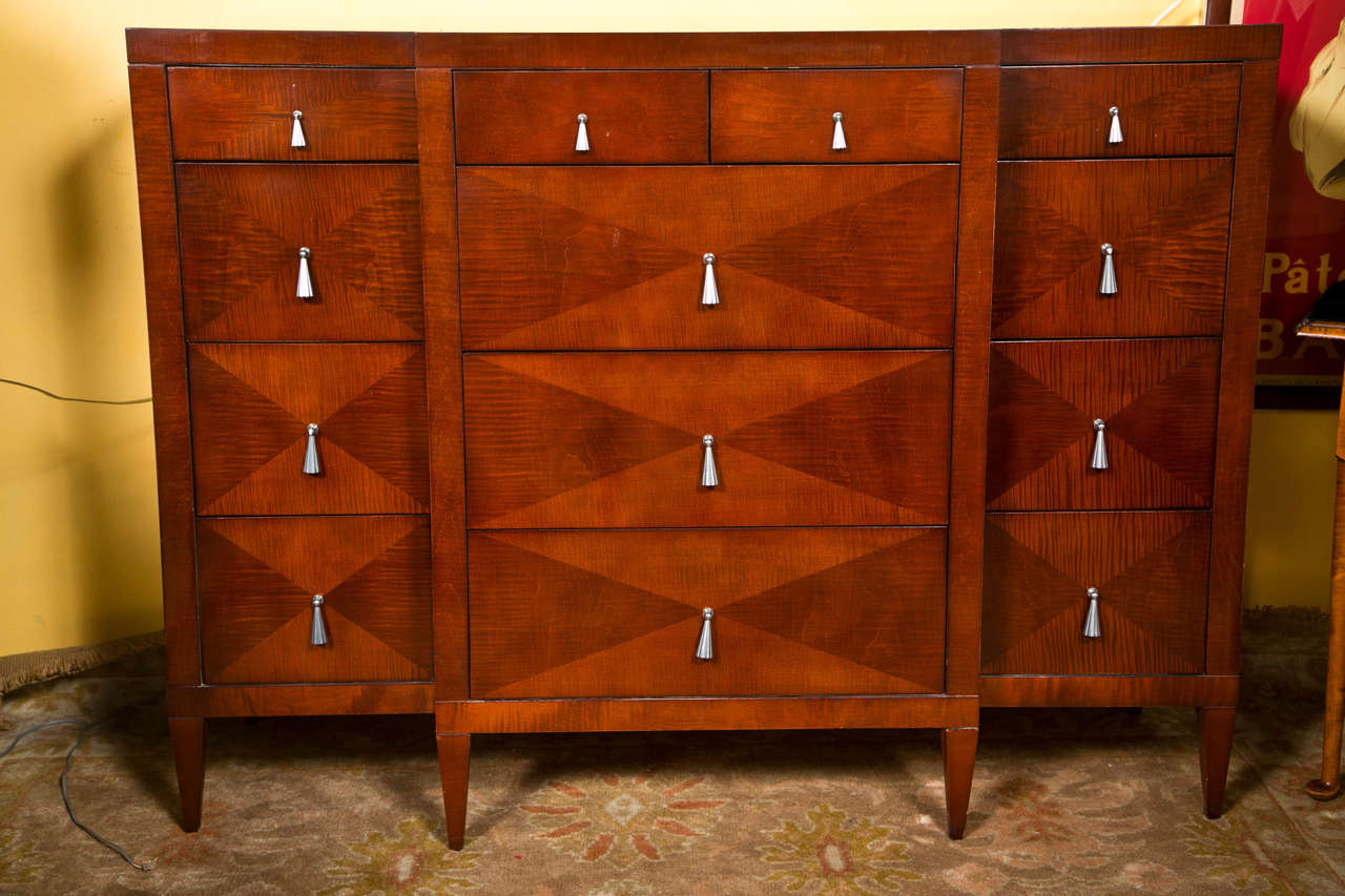 An attractive dresser in Art Deco style by Baker, 20th century, the dresser has a parquetry exterior wth silver tear-drop pulls, oak secondary, raised on square tapering legs.