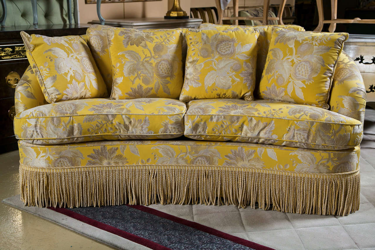 A lovely kidney shaped settee, fully upholstered in gorgeous golden embroidered silk, cushioned seat, the bottom with tassels, comes with four pillows.