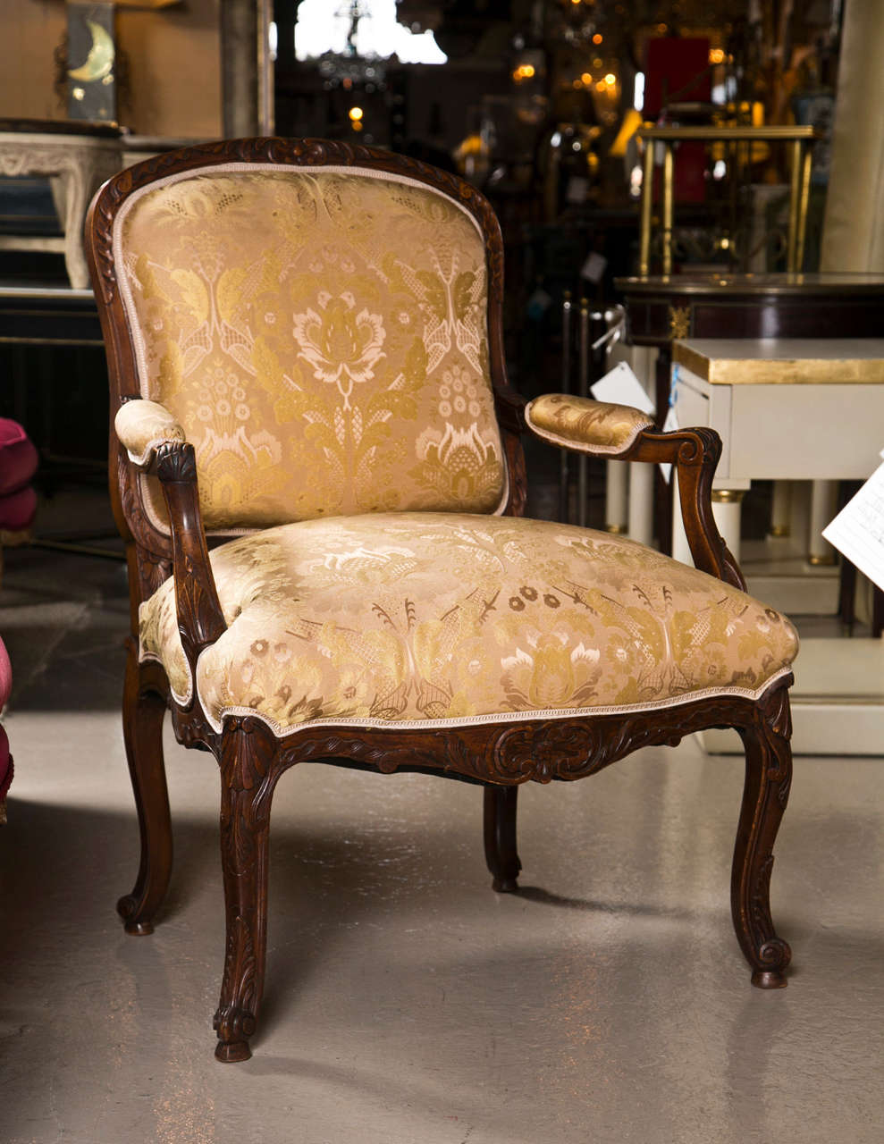 Pair of French Louis XV style walnut bergere chairs, circa 1940s, the padded square back with down-swept arms joint by padded seat, raised on carbiole legs.