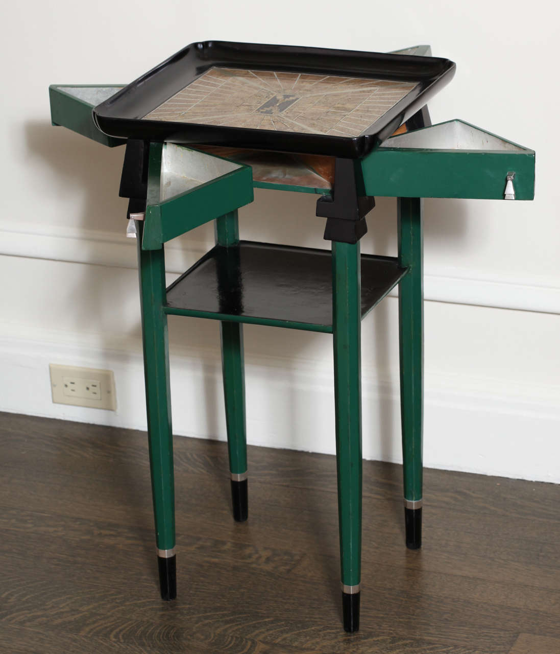 Exquisite and unusual green and black lacquered side table has top inlaid with shagreen, ivory and metal in geometric design. The tabletop has four cornered dimples and is slightly concave. There is a pull out hinged triangular drawer with silver