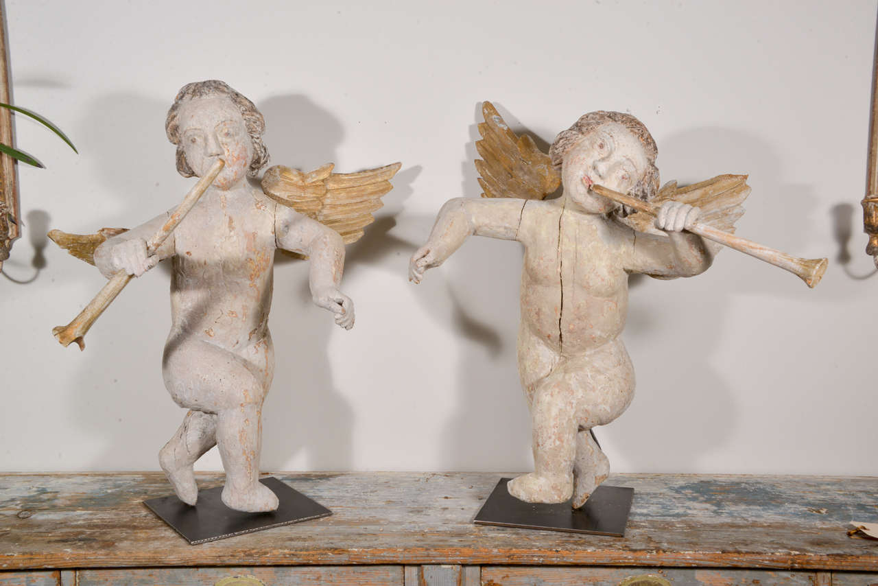 Pair of 17th century carved winged angels with trumpets in their hands. Original polychrome and gilt visible.