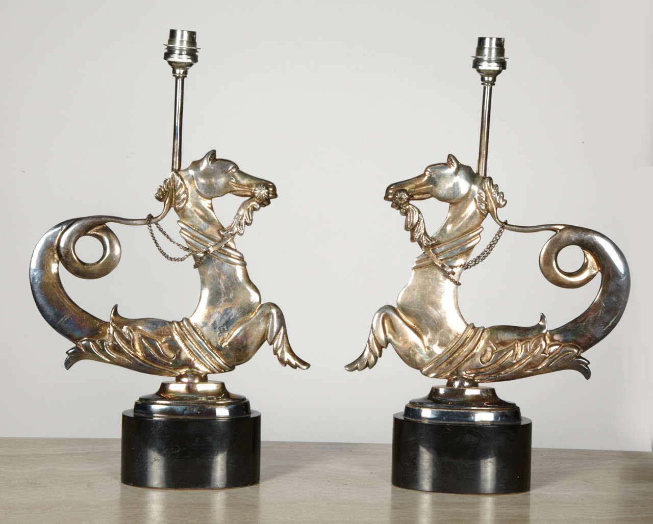Beautiful pair of sea horse silvered metal lamps on marble base.
