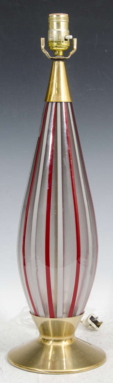 Une paire de lampes de table vintage avec des corps en verre de Murano rayé rouge, blanc et transparent et des bases en laiton.