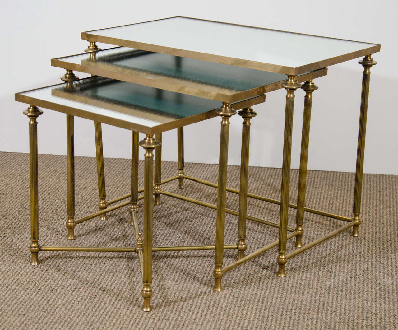 A Mid Century Set of Three Mirror and Brass Nesting Tables