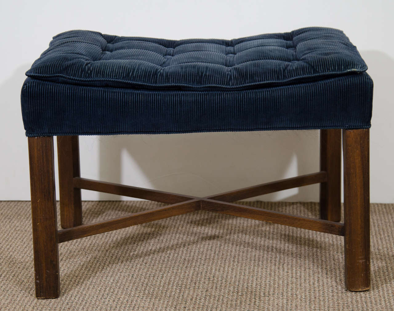A vintage pair of walnut framed stools with button tufted blue corduroy seats.