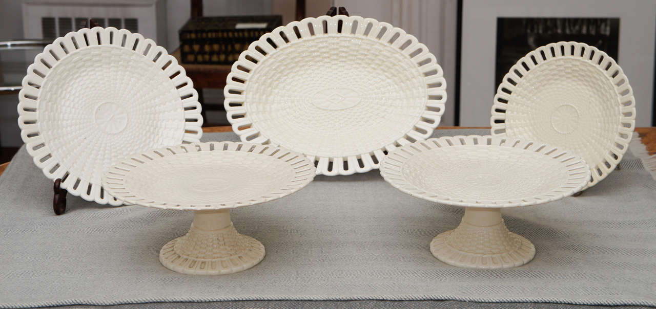 Five Wedgwood creamware serving pieces including three footed cake stands in lovely basket weave pattern. One larger oval platter and single plate. Measurements are for the two round footed cake plates.