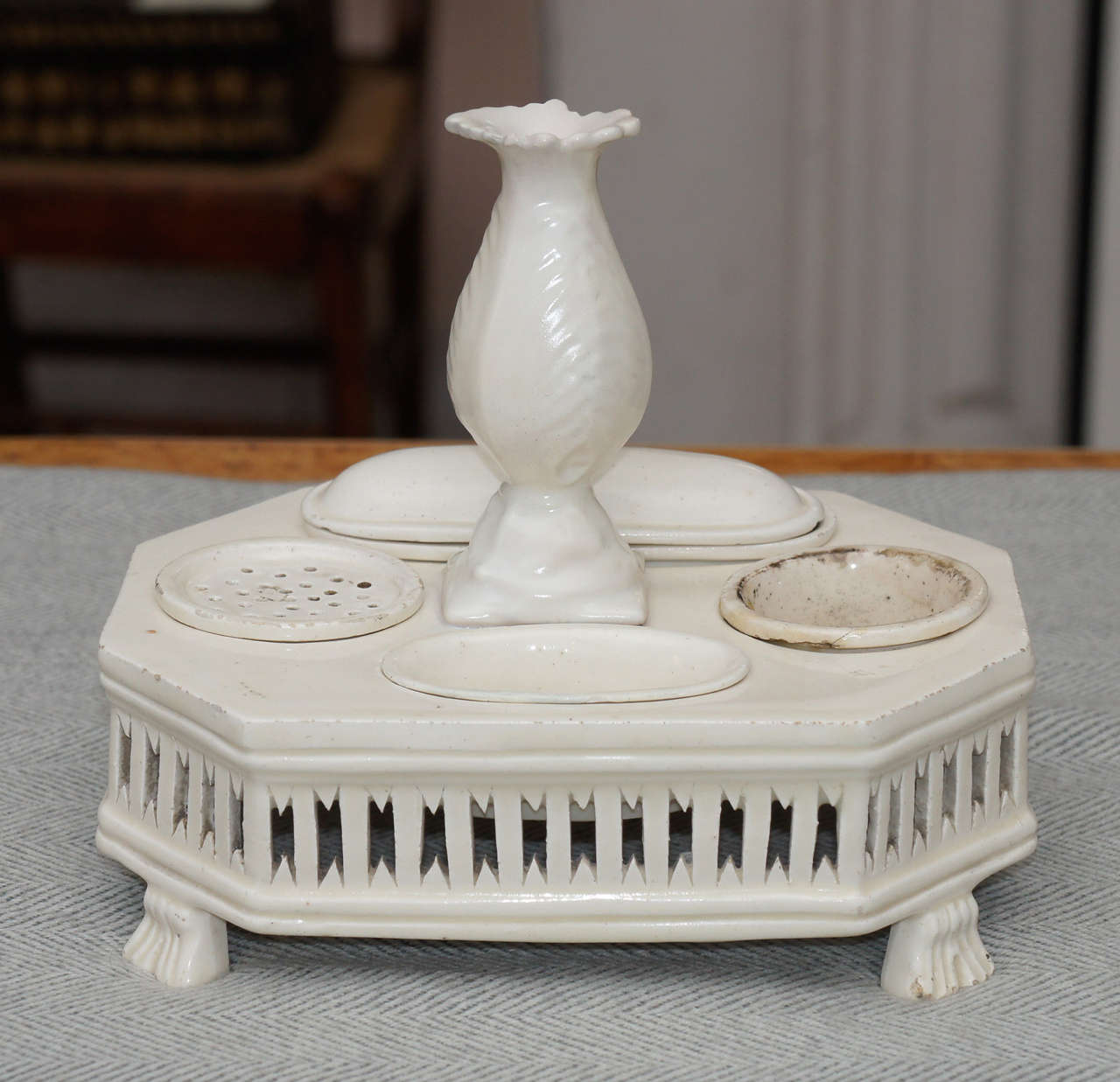 English creamware inkwell. Probably Wedgwood. Pierced base supported
by feet. Bud vase, inkwell, sander and pin dish with lid.