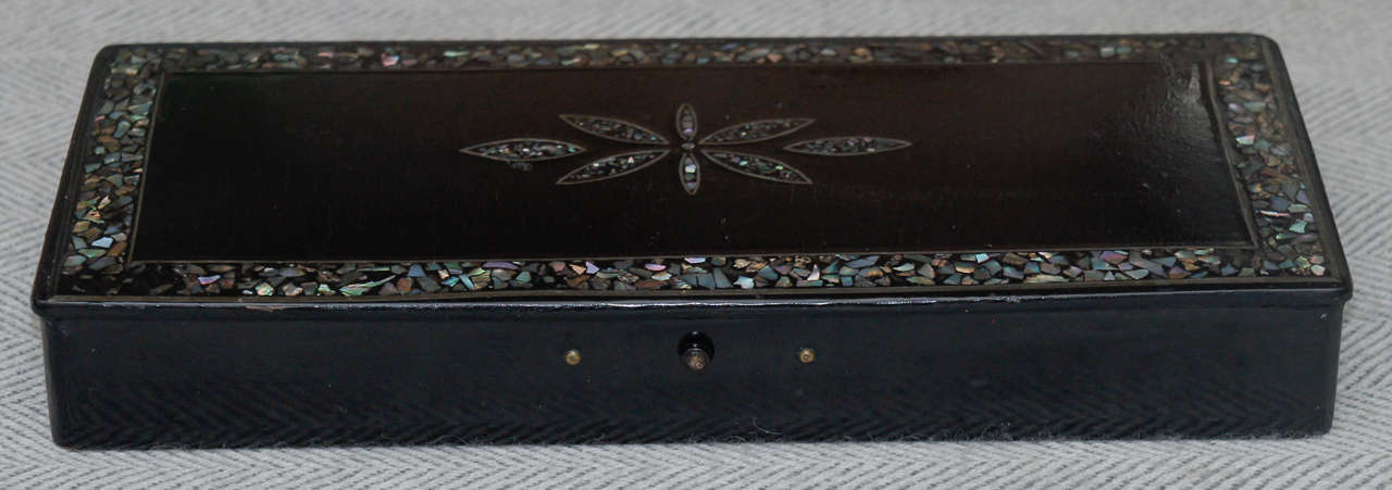 Louis Philippe black lacquer papier mâché pen box with mother of pearl.
Delicate inlay around the border and flower inlay at the center. Two sections.
In the interior of the box for pens and small button on the outside to press.
And open the box.
