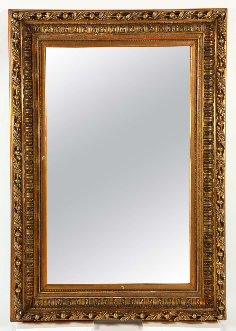 This is a substantial gilt wood frame with wonderful carving surrounding a rectangular plate. At over six feet tall, this mirror makes an impact in any room where a bit of drama is required.