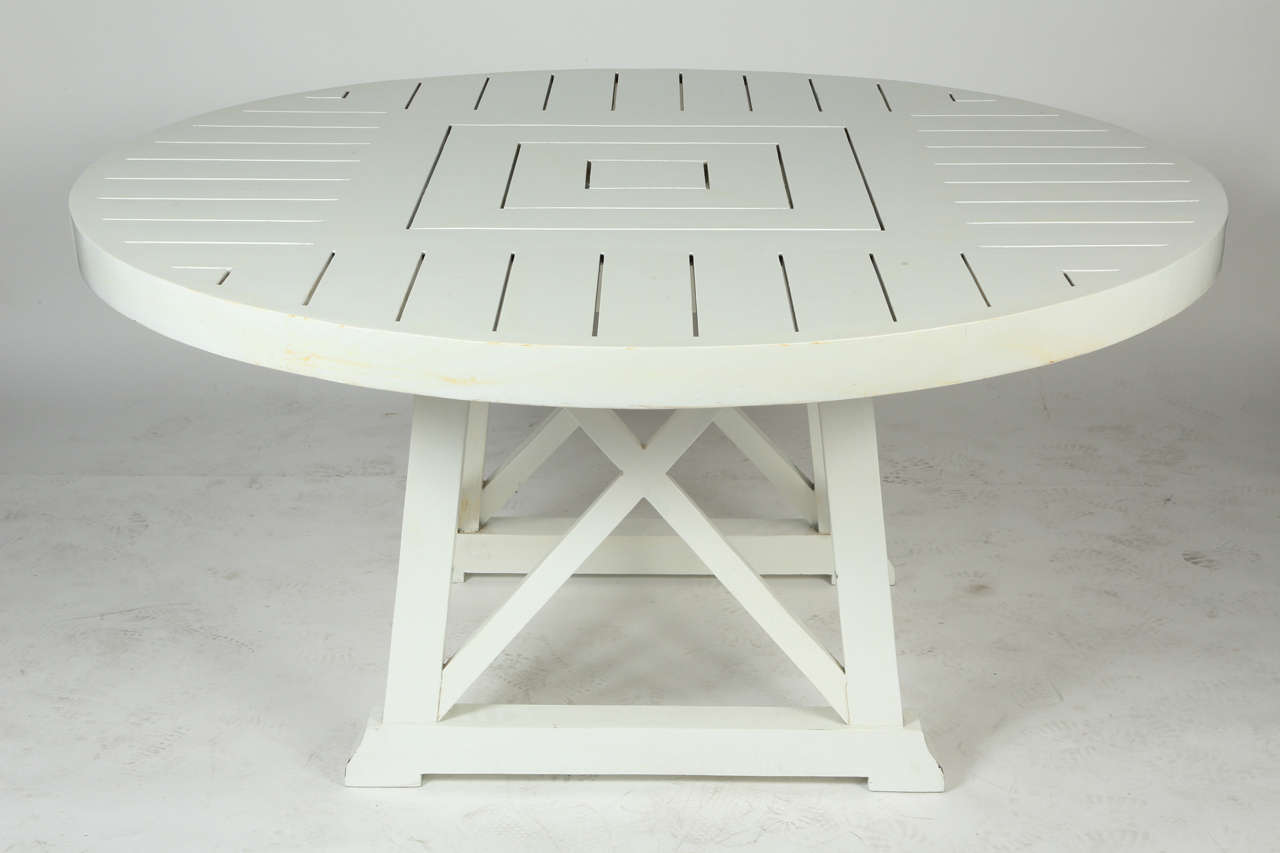This chic table made of teak is painted a high gloss white finish that allows it to work inside or outdoors. The 60 inch round top is supported by 4 solid legs with cross braces. 
This table has a very versatile design that would work well in