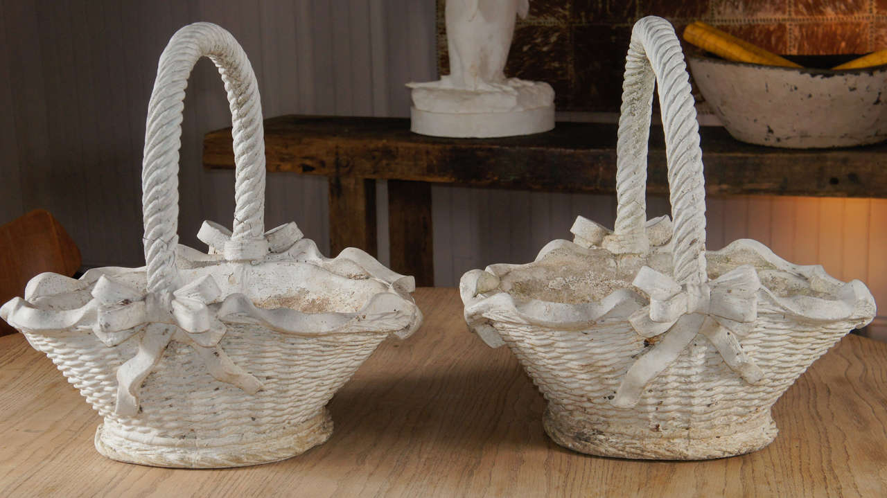 pair cement handled garden baskets - wicker pattern - adorned with ribbons and bows - drainage hole - in original crusty white painted surface