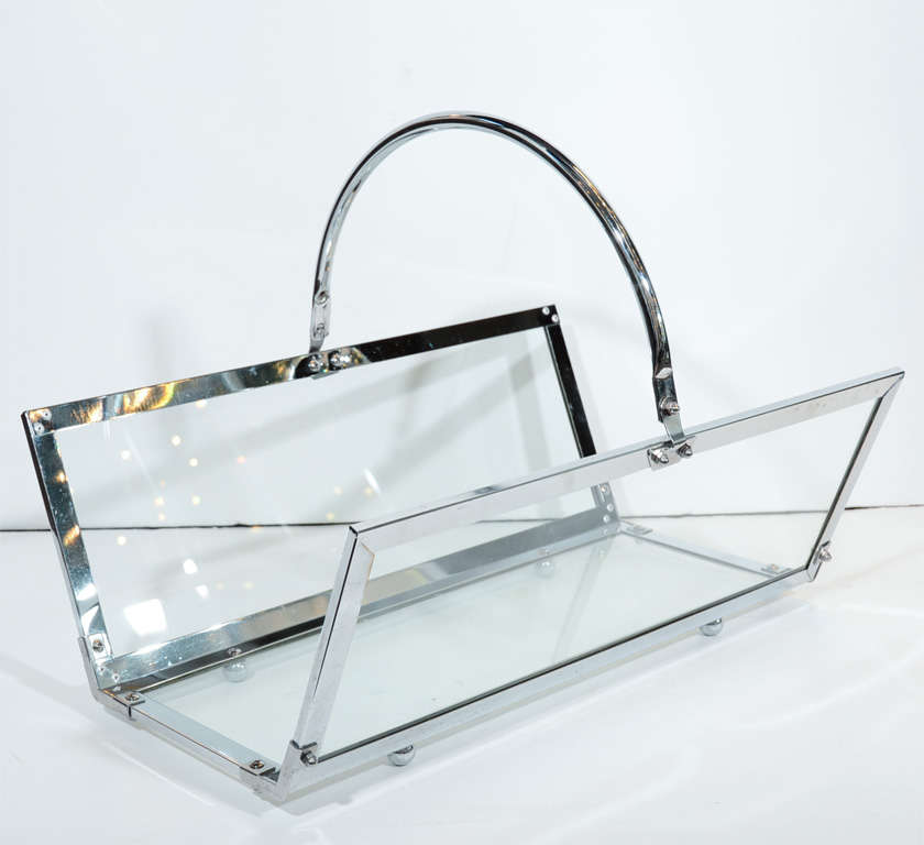 Glass and chrome log holder with adjustable curved handle features three chrome-framed glass panels that rest atop four chromed ball feet.