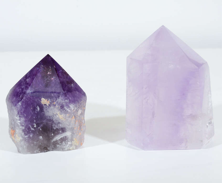 Exquisite pair of Amethyst geodes from the William Randolph Hearst Collection. Larger geode in soft lavender and pink tones features exceptional beveled details. Smaller geode in rich purple tones features severe pointed top with irregular organic