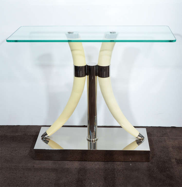 Sexy glass topped table features two formed horn supports with gentle curves atop a chromed base with chrome details.