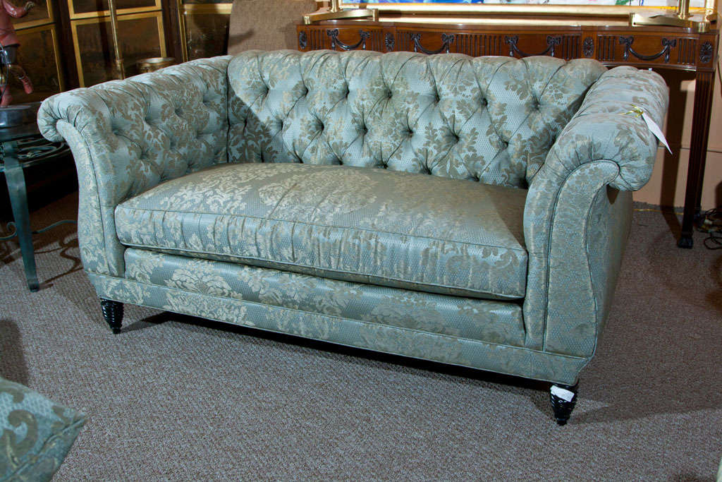English Georgian style loveseat, tufted back and rolled arms, cushioned seat, raised on ebonized legs.