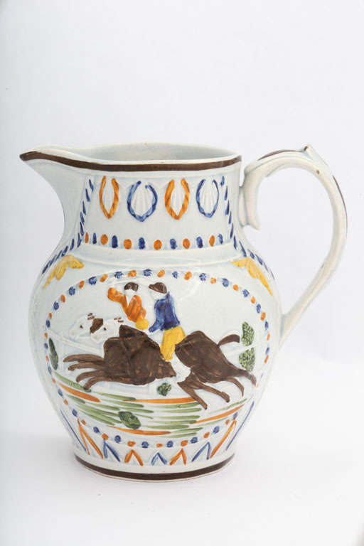 A rare English pearlware pitcher molded with racing scenes and decorated in underglaze Pratt colors