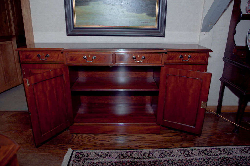 Made for us in England by a cabinetmaker with whom we have been working for over 30 years, this quality break front server/credenza features four drawers over four raised panel doors that conceal cupboards with a bisecting single shelf.
Made in