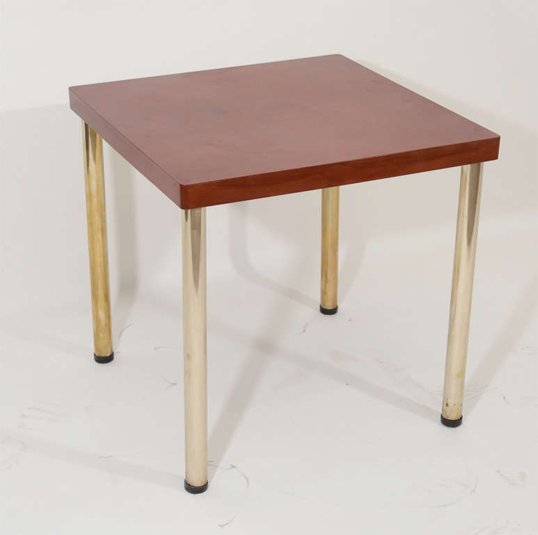 Table with red/orange bakelite top and brass legs by Rene Herbst, French, late 1940s. The legs for this table unscrew so the table can be easily dismantled.