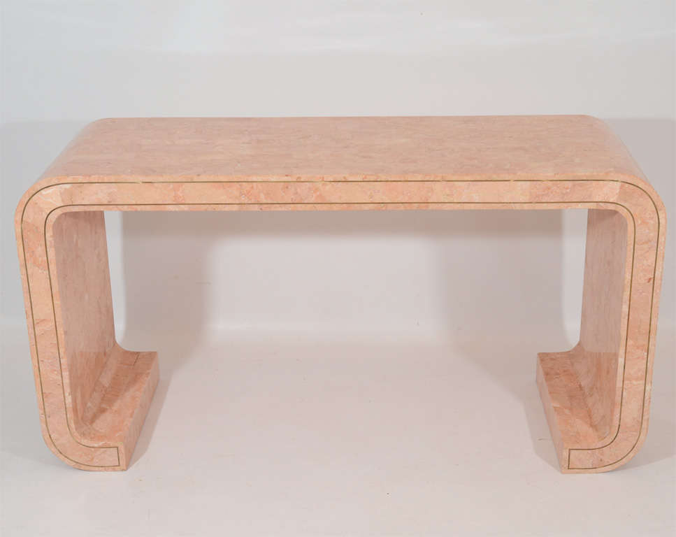 Beautiful salmon colored console table surfaced in coral stone tiles and accented with inlaid brass detailing. Please contact for location. 