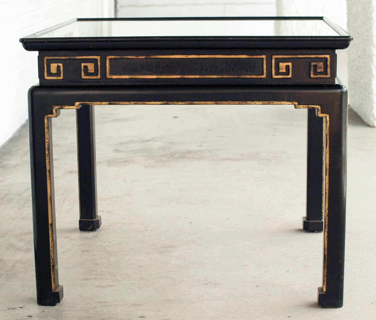 Maison Jansen Chinoiserie end tables in black lacquer with gold accent.  The tops of the tables are painted gold with black accent and have inset glass.  