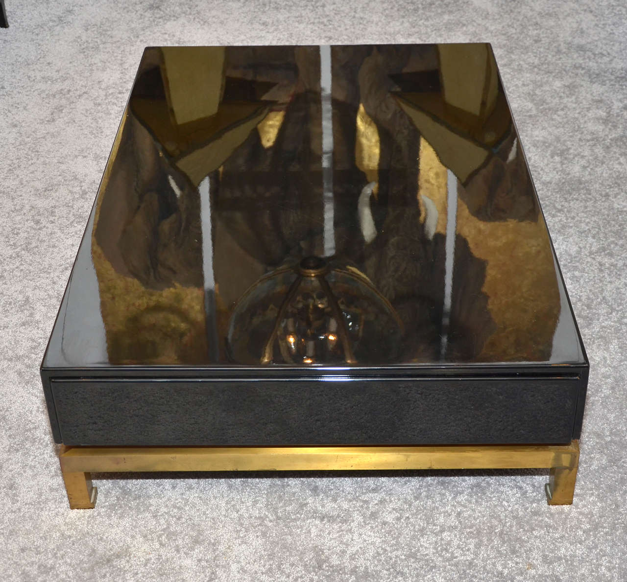 1970s coffee table by Guy Lefèvre for Maison Jansen in black lacquered wood, with one drawer divided in racks on either side; base in gilded patina bronze.