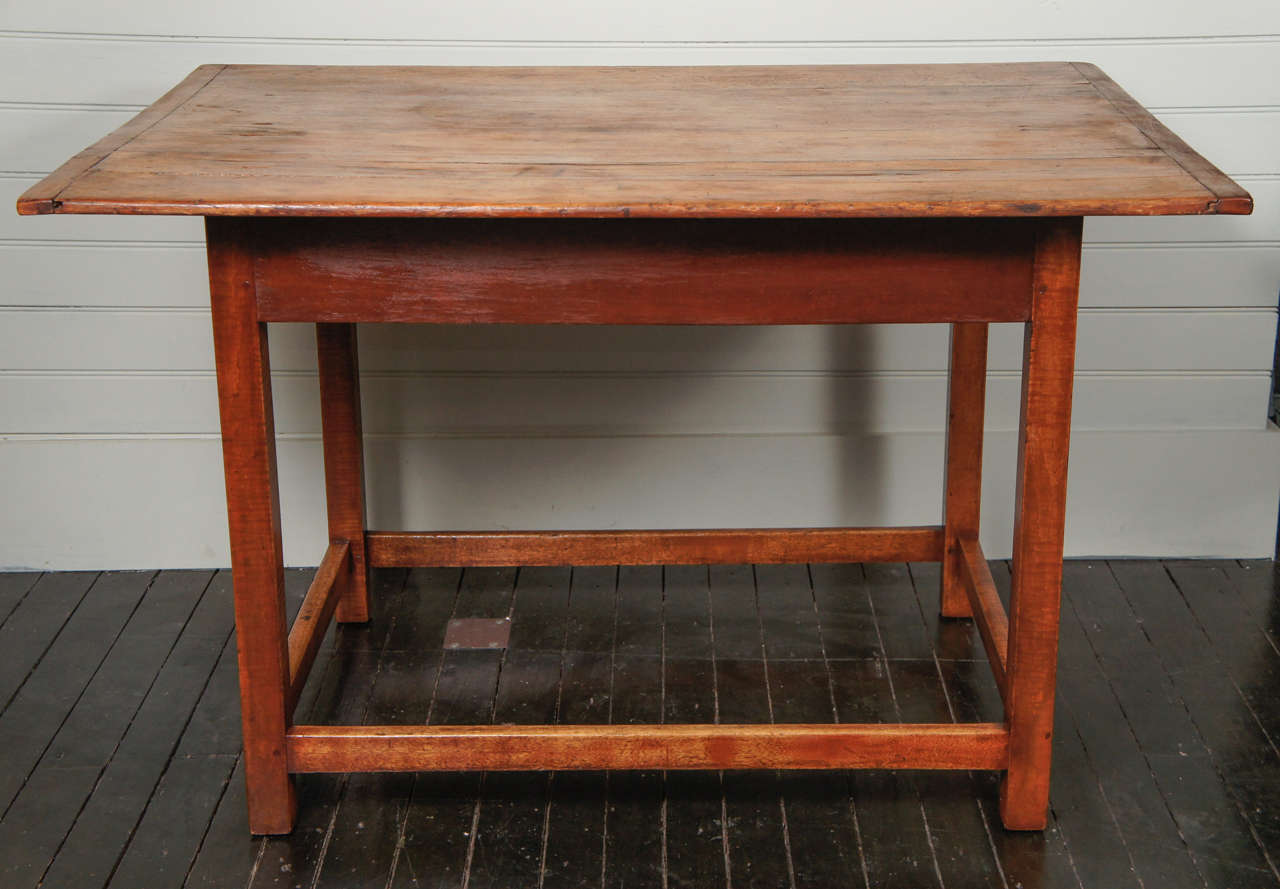 Eighteenth century country chippendale table, with striped, solid, tiger maple legs. Retaining its original pine top, with bread board ends. legs and stretchers of tiger maple, and pine skirt, with old red stain. A beautiful example of this form.