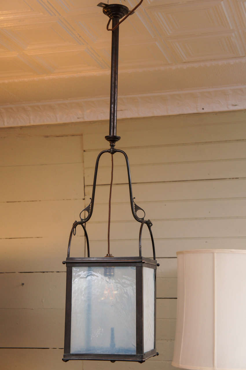 A single lantern, retaining its original gas jet, and newly wired for electric. Elegant arches, and finely cast dragon faces, clench small brass rings. It's simply a great design, with spare, elegant details.
