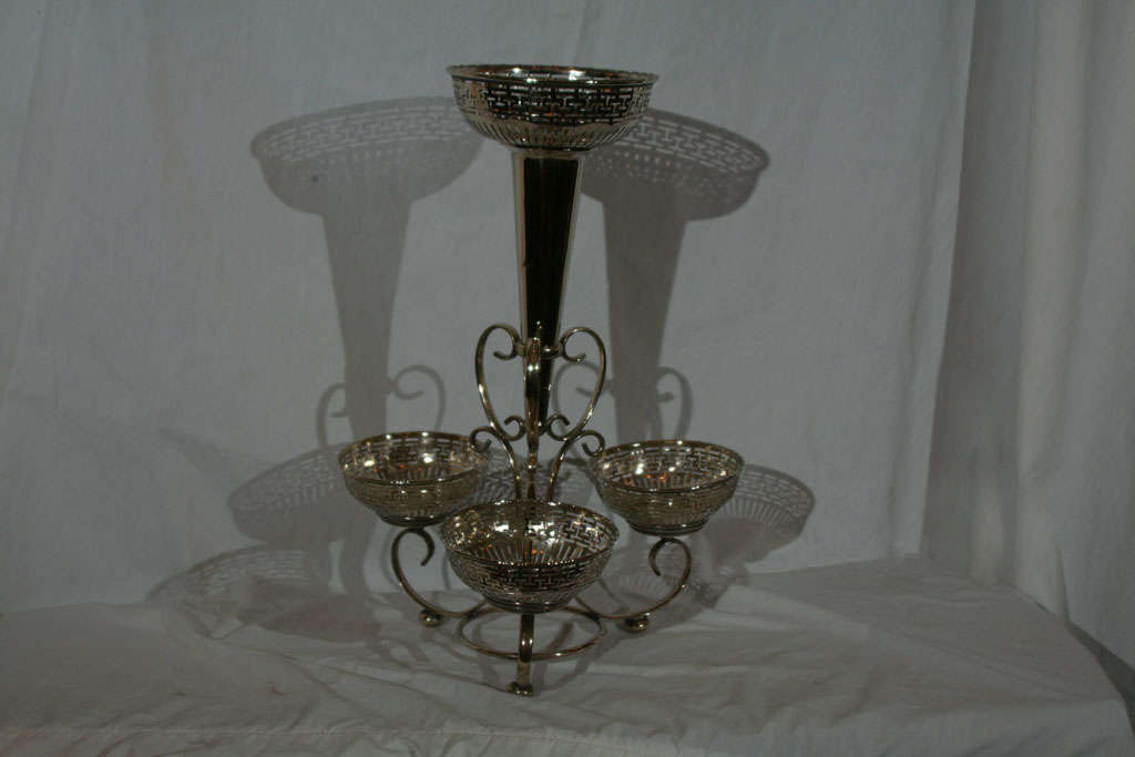 Siverplate epergne features Greek key fretwork around top of trunpet center and each of the three baskets