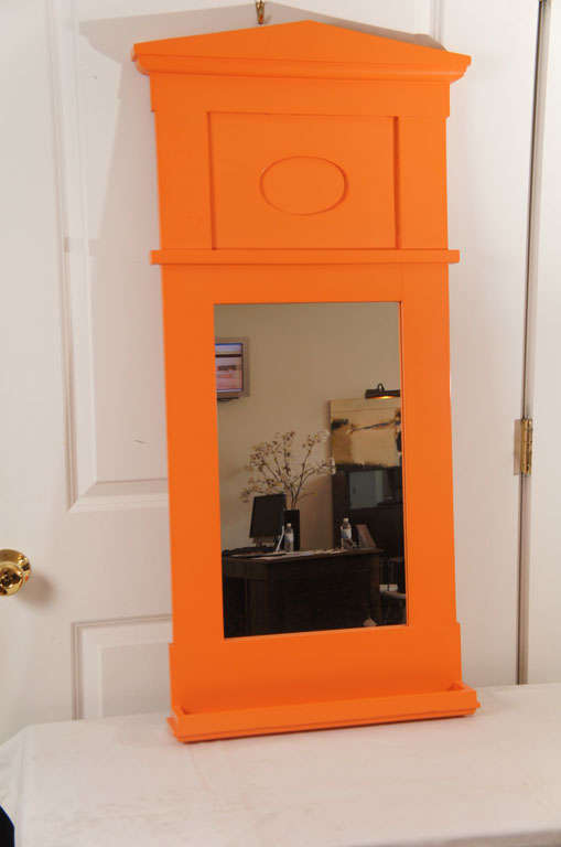 a wooden pediment style mirror. freshly lacquered,in a perky, fun cantaloupe color.