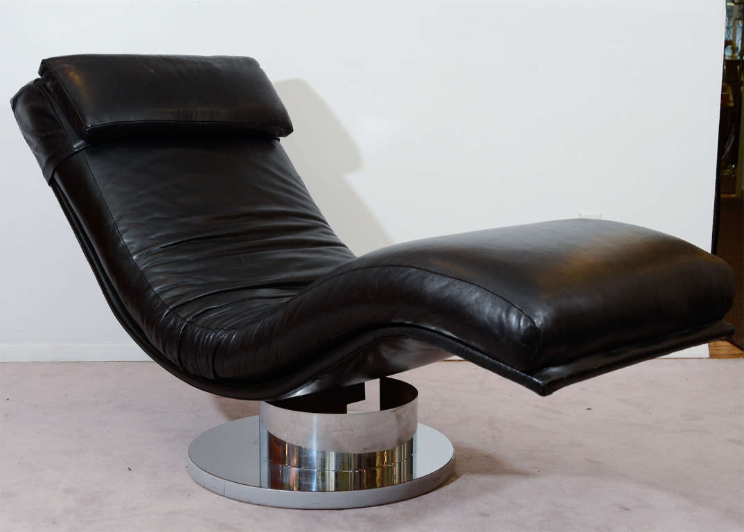 A vintage chaise by Milo Baughman with a circular, chrome pedestal-form swivel base and black leather upholstery.